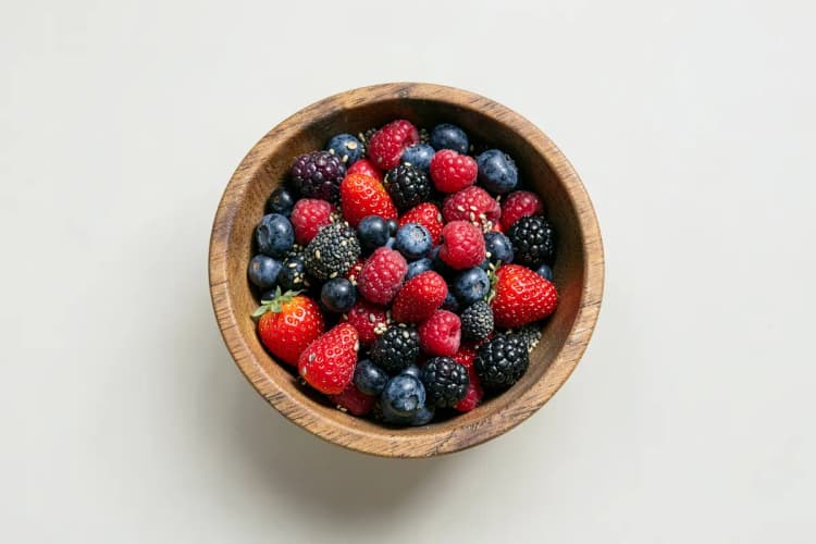 Tigela de frutas vermelhas e sementes, representando nutrientes.