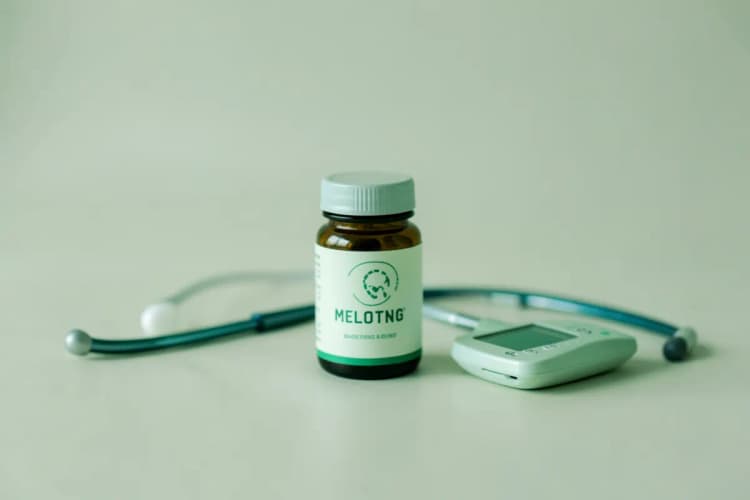 Frasco de melatonina ao lado de um estetoscópio e um medidor de glicose.