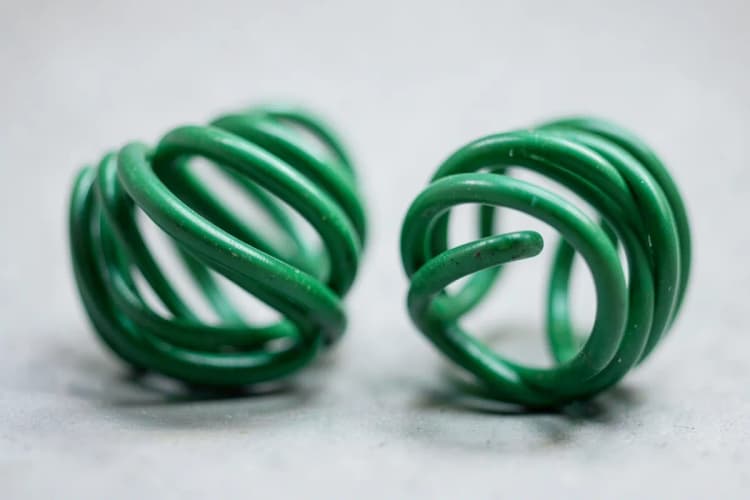 Uma mola comprimida e uma mola relaxada, lado a lado, para representar a relação entre colágeno e elasticidade/dor.
