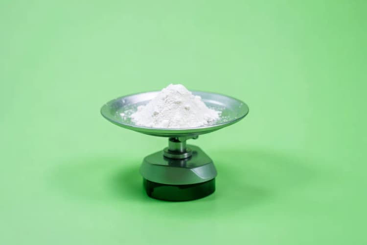 Uma balança de precisão com um pequeno monte de pó branco em um dos pratos, simbolizando a dosagem de melatonina