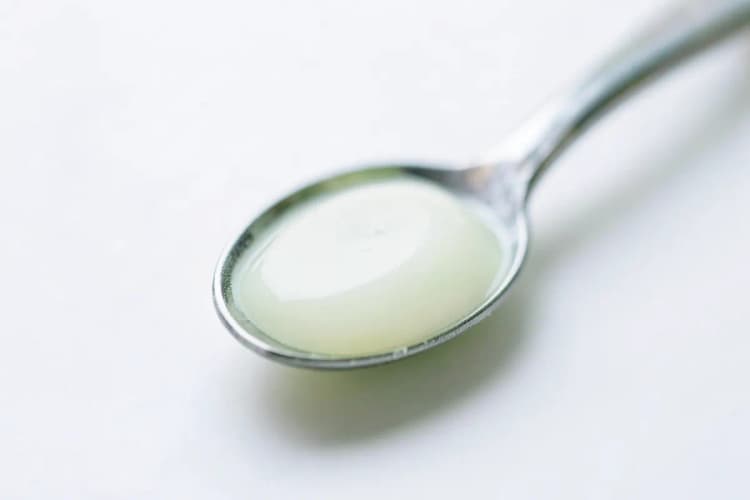Uma colher de chá com óleo de coco sólido branco.