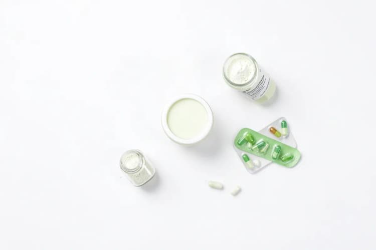 Diferentes tipos de suplementos de magnésio em pó e cápsulas dispostos em recipientes.