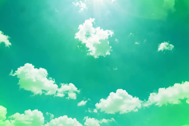 Um sol brilhante no céu azul com nuvens brancas, visto de baixo.