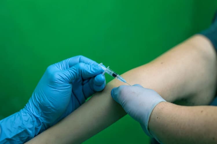 Profissional de saúde aplicando injeção intramuscular.